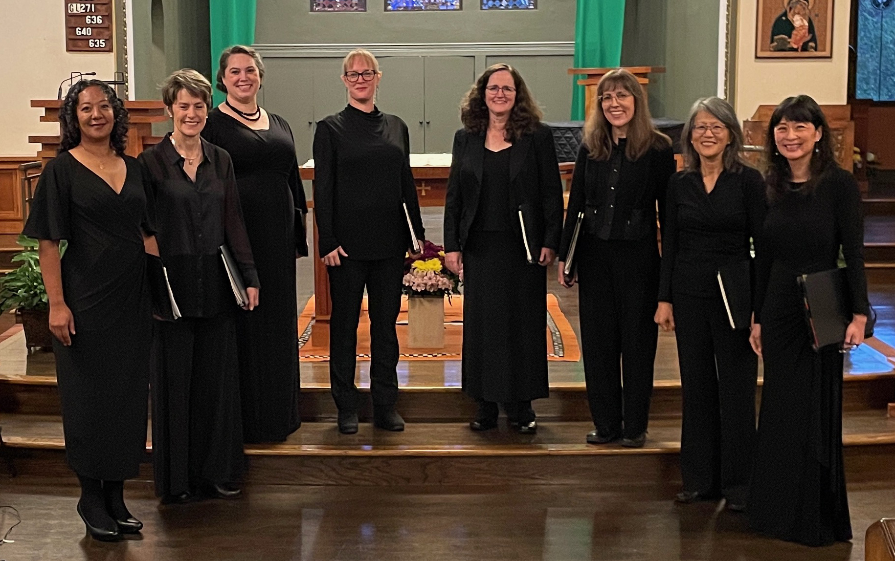 group of eight women in formal black outfits